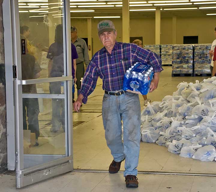 man carrying water out of a water distribution center